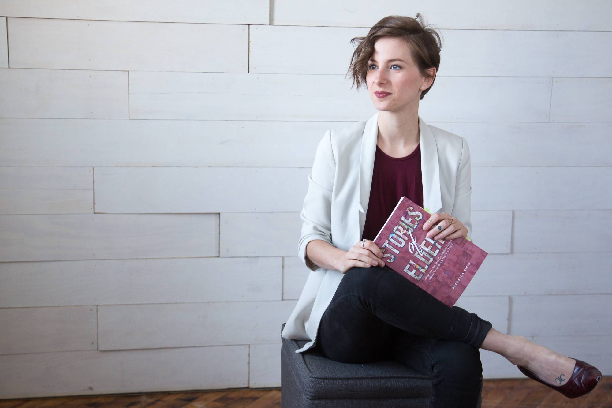 Veronica Kirin sitting on a chair holding a book